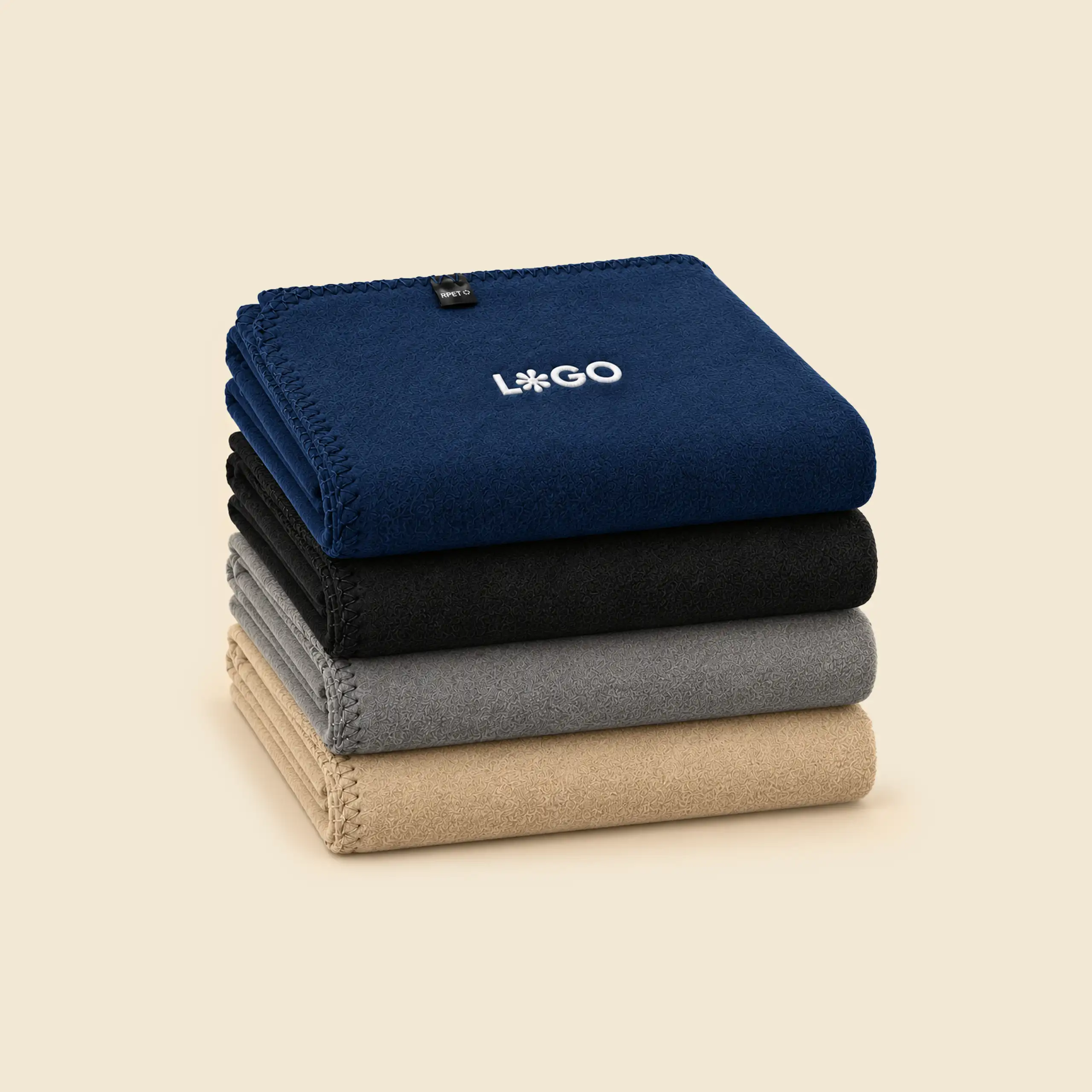 Cuatro mantas bordadas personalizables dobladas y apiladas en azul marino, negro, gris y beige, con remate de punto festón