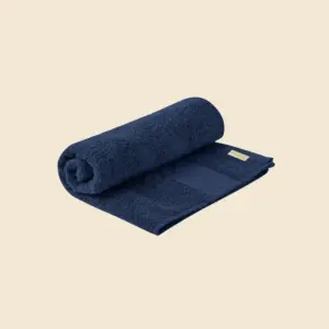 Toalla de manos personalizada de algodón orgánico en color azul marino, semienrollada, con etiqueta Organic Cotton