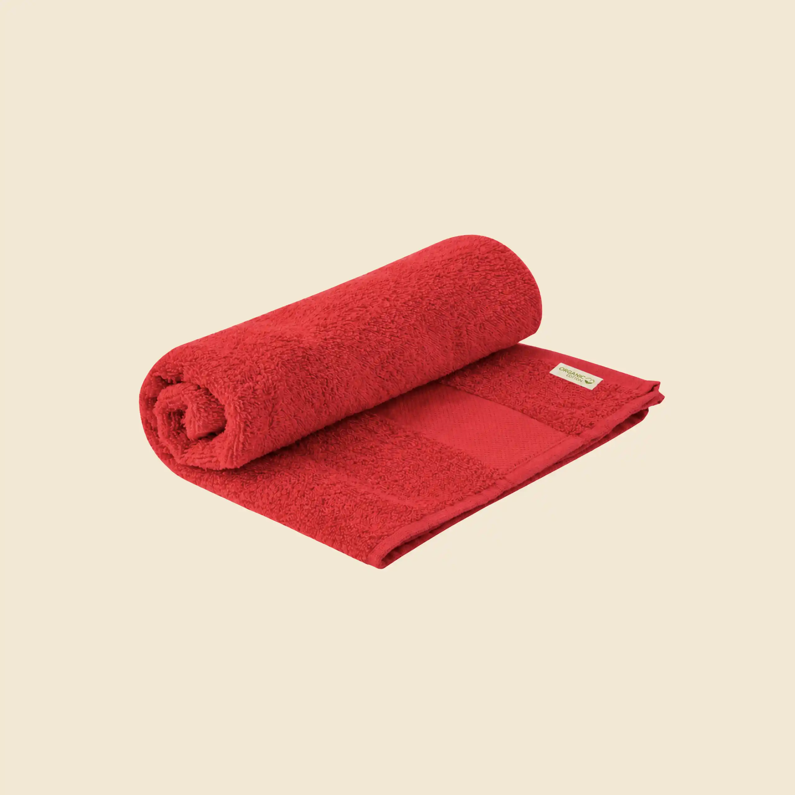 Custom hand towel in red organic cotton, partly rolled, with Organic Cotton label