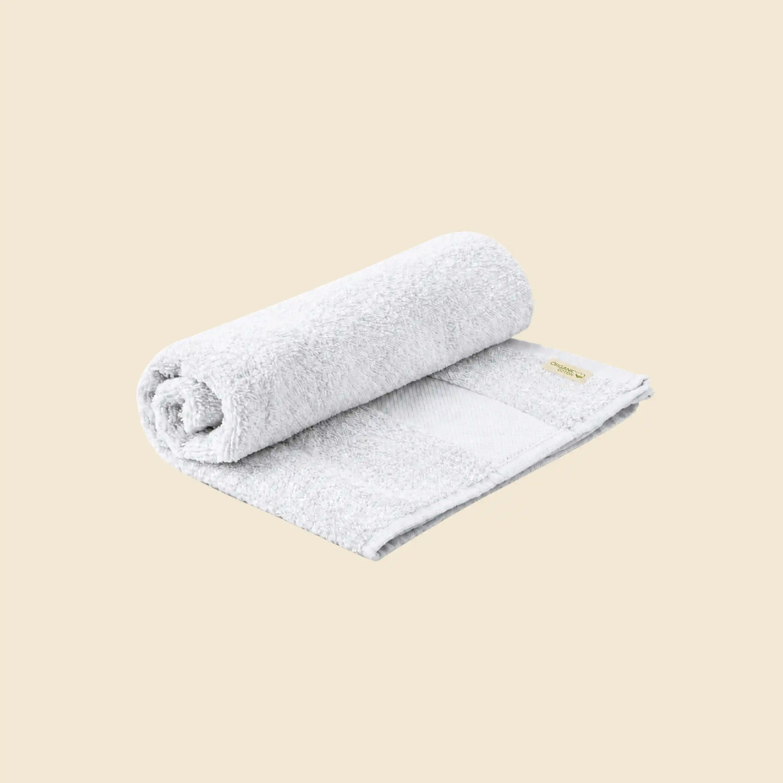 Custom hand towel in white organic cotton, partly rolled, with Organic Cotton label